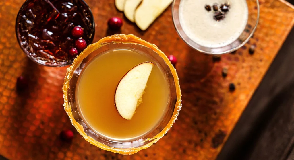 A glass of cocktails with fruit on a table