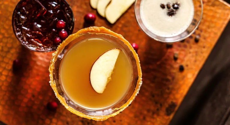 A glass of cocktails with fruit on a table