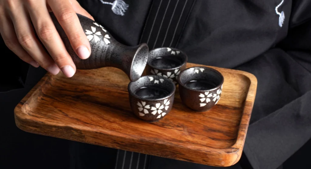 Verser de l'alcool japonais dans des coupelles