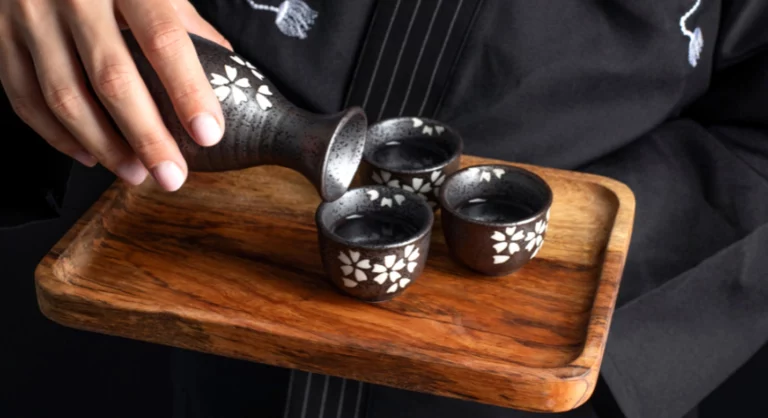Verser de l'alcool japonais dans des coupelles