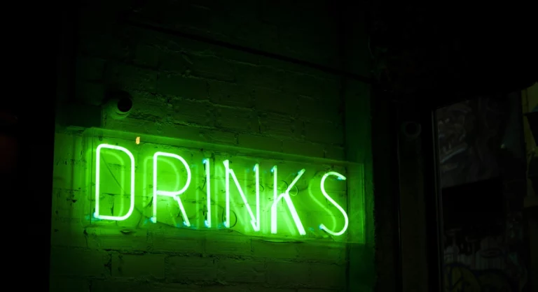 word DRINKS neon at night