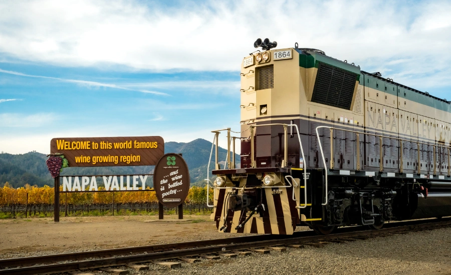 Train en arrêt avec un gros panneau Napa Valley derrière et ciel bleu