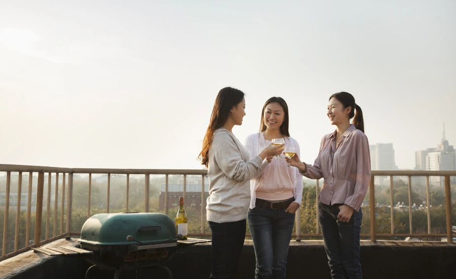 Trois femmes asiatiques discutant sur un rooftop.