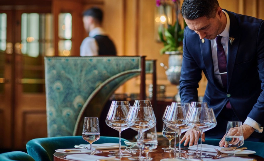 Un homme qui prépare une table de restaurant.
