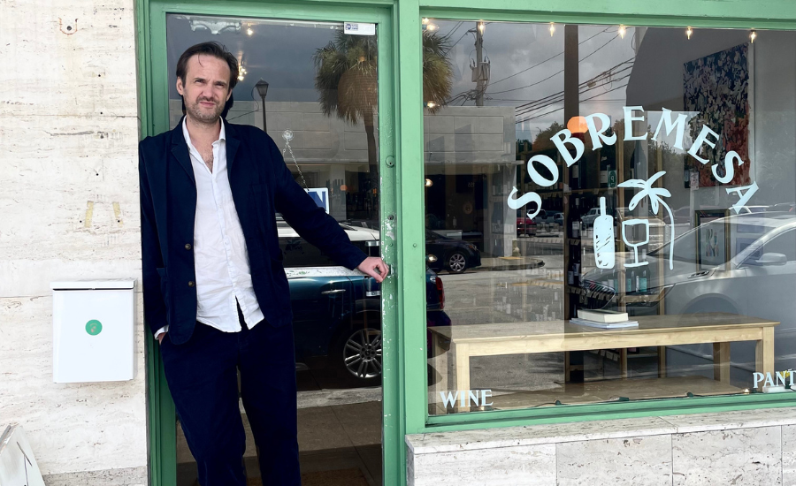 propriétaire d'un magasin de cocktails et vins pris en photo devant son magasin