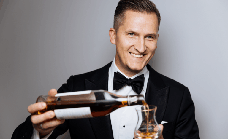 serveur chic versant un vin couleur ambrée avec le sourire