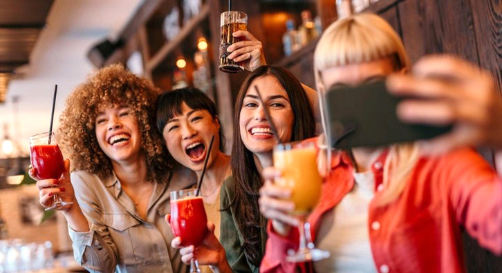 Young people taking a group selfie with their no-alcohol beverages