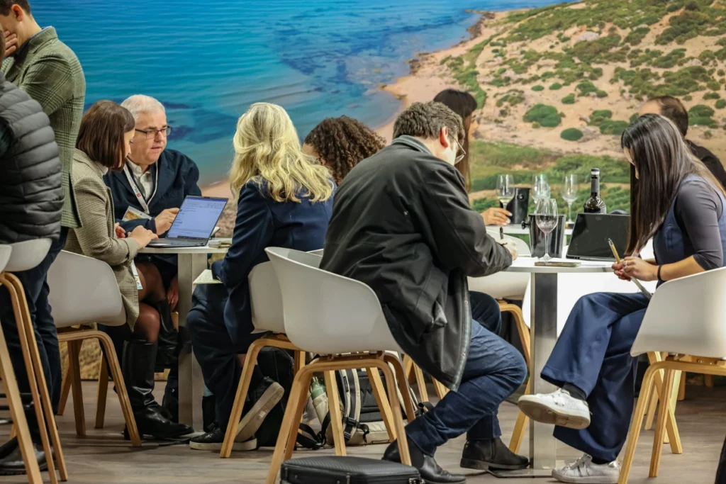 Acheteurs et exposants assis autour de tables et discutant lors de rendez-vous programmés à Wine Paris.