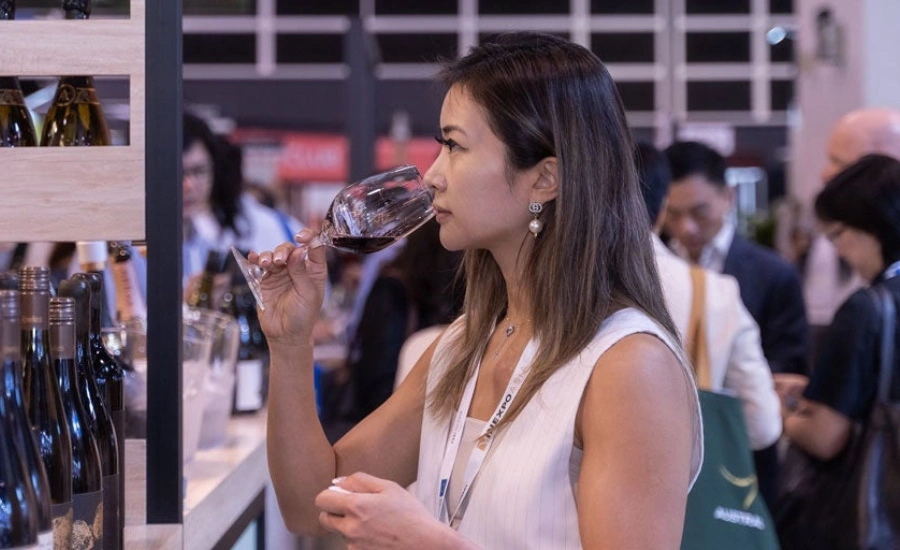 A woman who is sniffing her glass of wine before tasting it