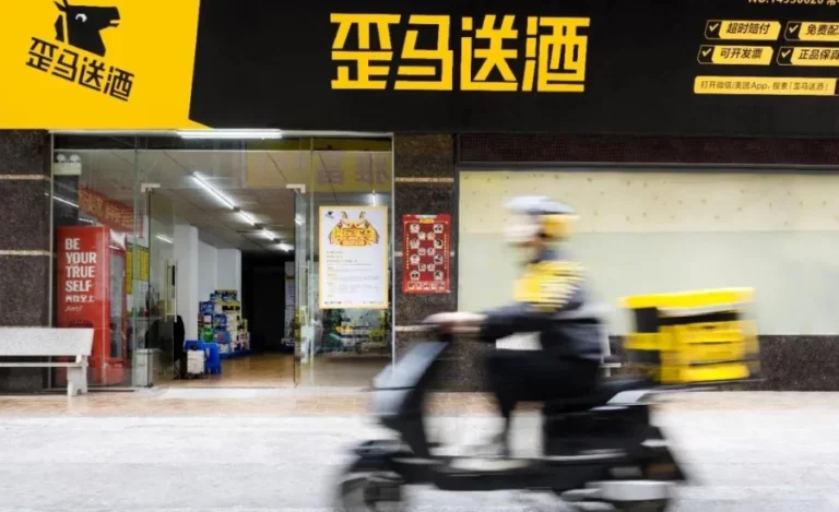 Un livreur conduisant un scooter devant une boutique jaune et noire