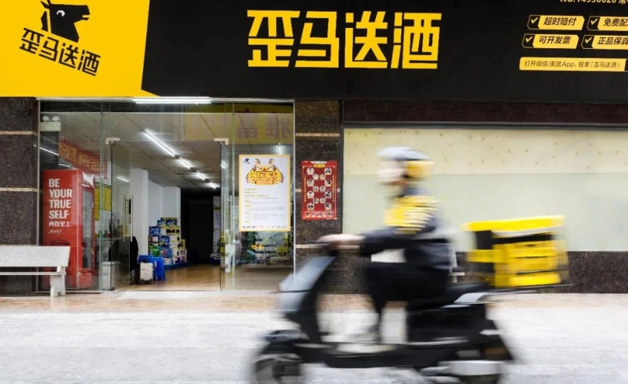 Un livreur conduisant un scooter devant une boutique jaune et noire