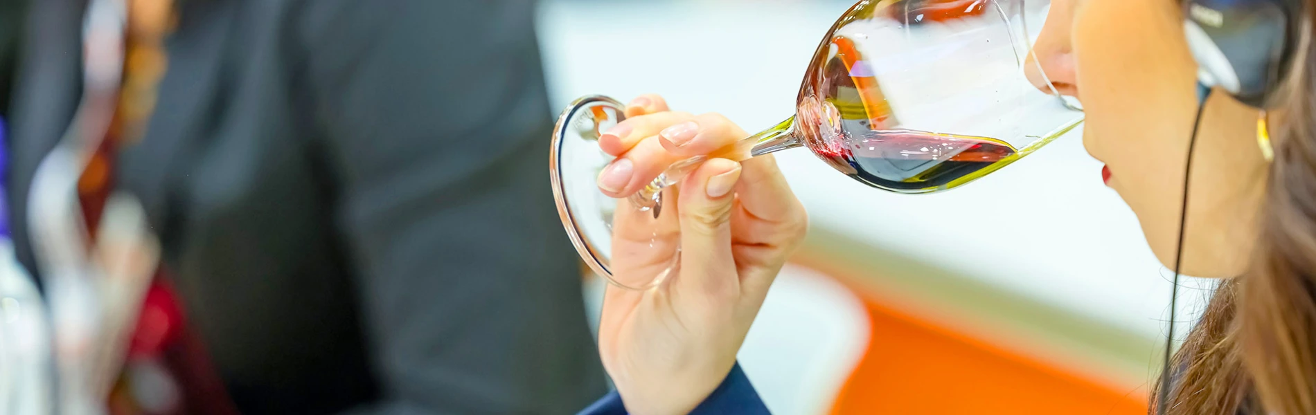 Woman who is smelling into a glass to find wine taste